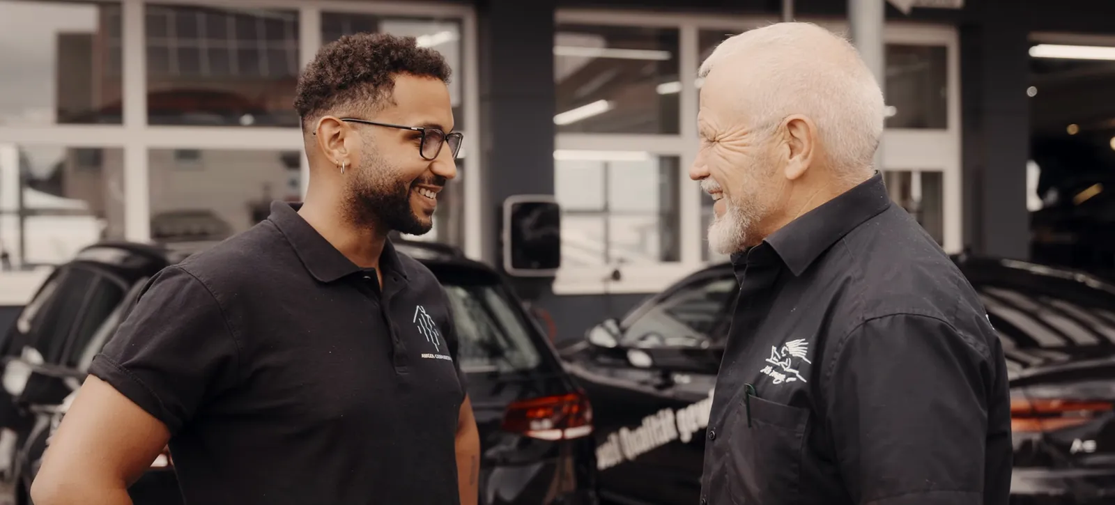 Inhaber Joan Vieira Amigo im Gespräch mit einem Geschäftskunden vor einem Autohaus, Gebäudereinigung für Unternehmen